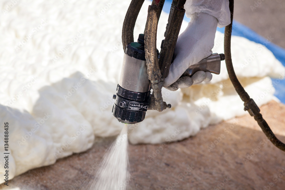 Technician spraying foam insulation using Plural Component Spray Gun - obrazy, fototapety, plakaty 