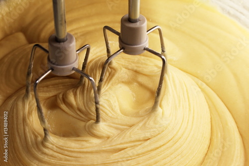 Electric hand mixer with the dough for the pie photo