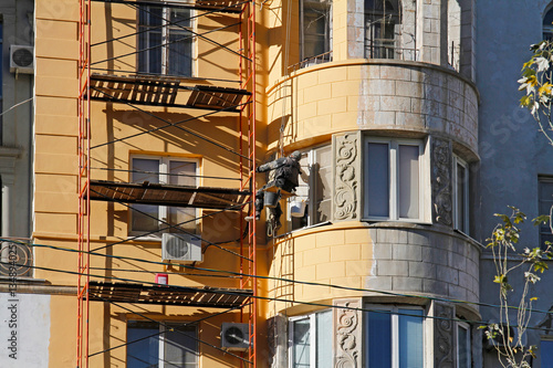 Builder worker painting facade of building house 