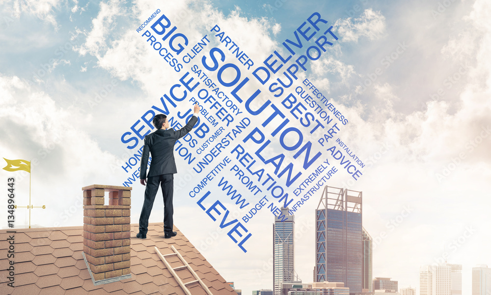 Young businessman standing on house roof and writing leadership Young businessman standing on house roof and writing leadership