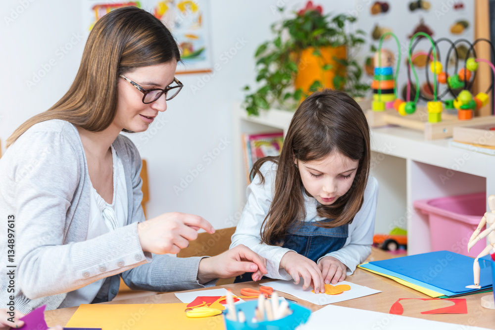 Teacher Working with Cute Girl in Preschool Classroom Teacher Working with Cute Girl in Preschool Classroom