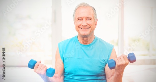 Portrait of senior man exercising with dumbbells