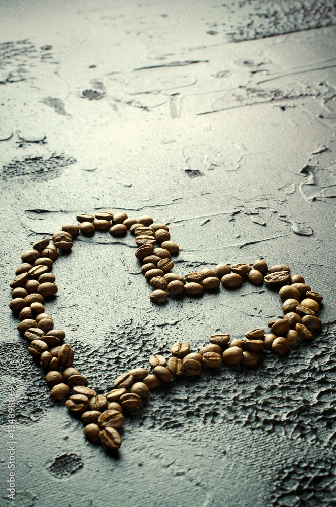 Coffee beans in heart shape on dark rustic background Coffee beans in heart shape on dark rustic background