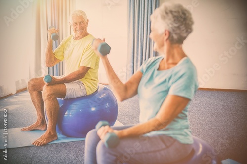 Seniors using exercise ball and weights