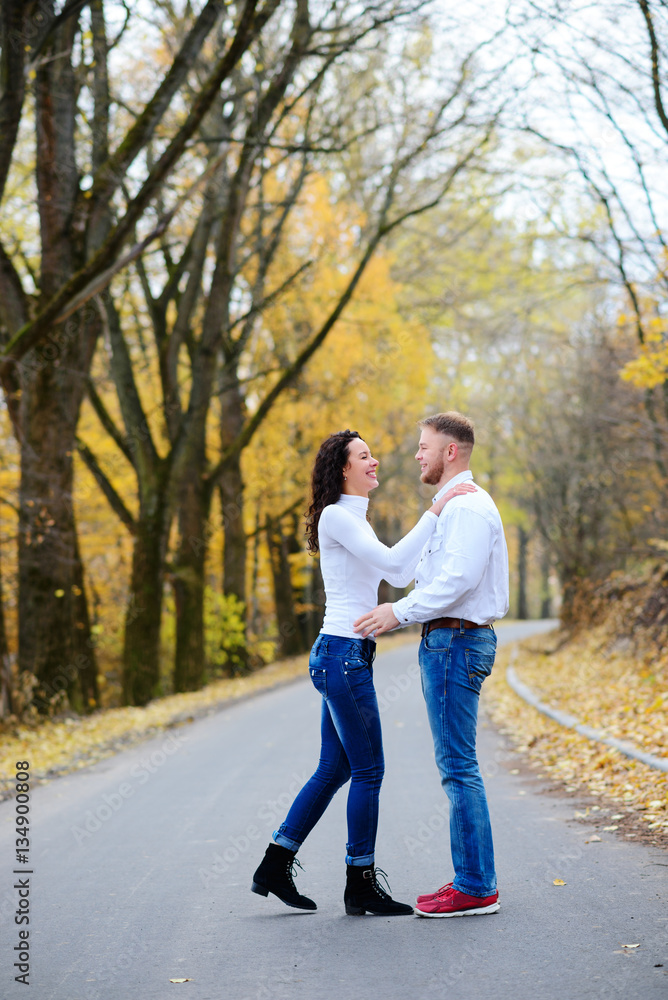 Portrait of young loving couple kissing in autumn park Portrait of young loving couple kissing in autumn park