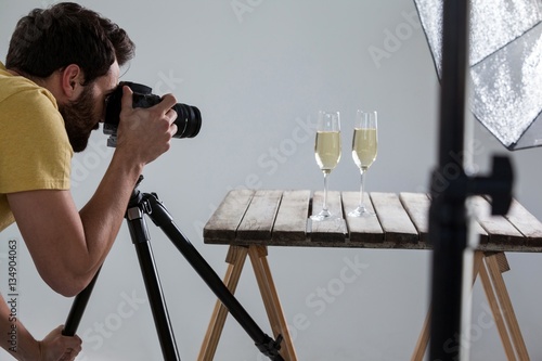 Male photographer photographing champagne glasses