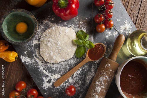 Preparing pizza with dough and tomato sauce