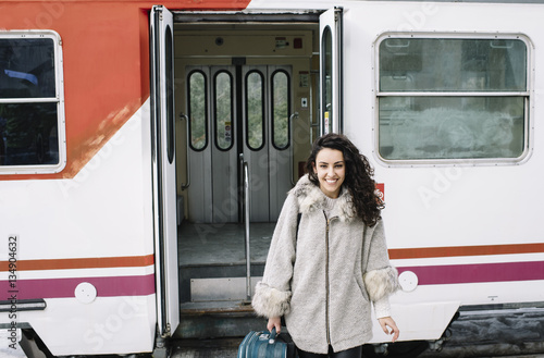 Girl with suitcase that goes down the coach of the train