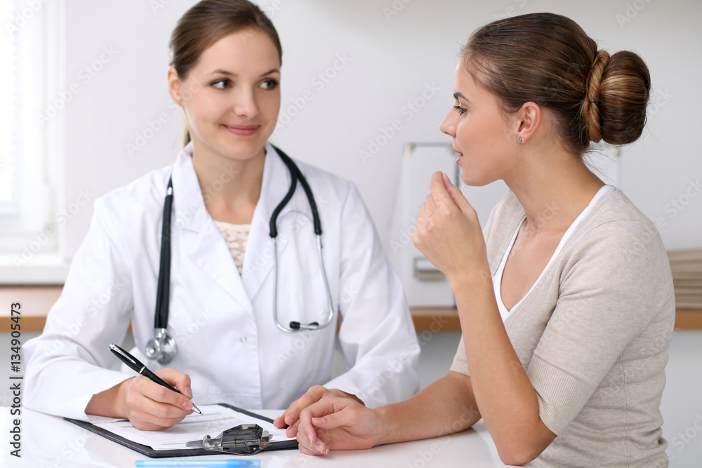 Doctor and patient sitting at the desk. Medicine and health care concept Doctor and patient sitting at the desk. Medicine and health care concept