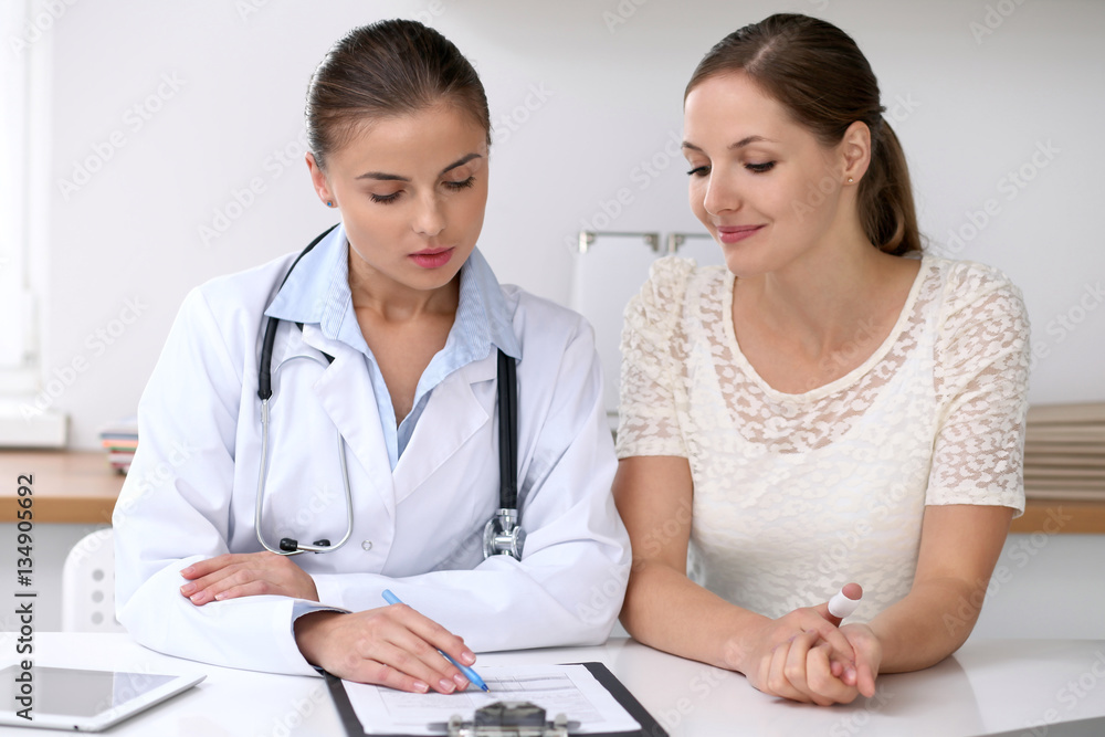 Doctor and patient sitting at the desk. Medicine and health care concept Doctor and patient sitting at the desk. Medicine and health care concept