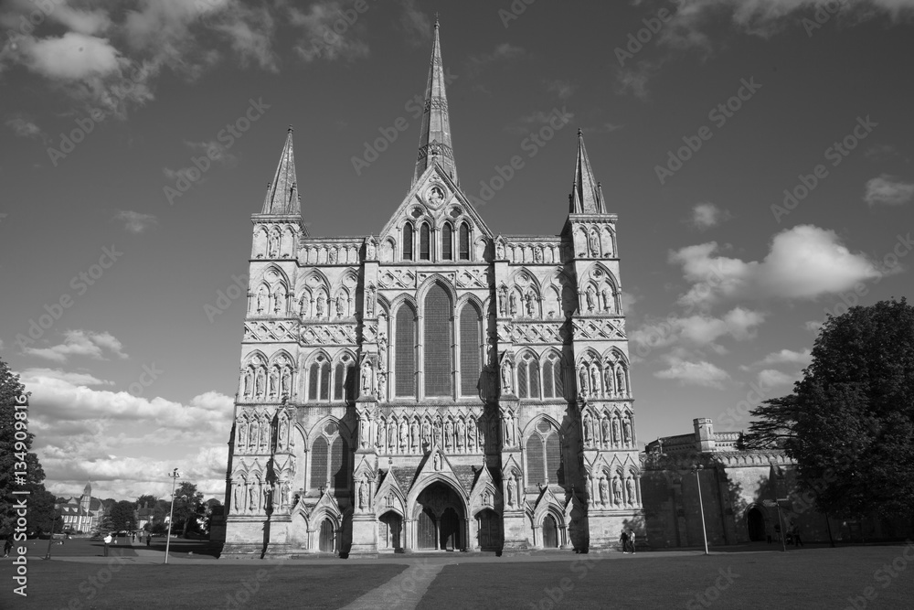 Black and white image of Salisbury Cathedral which has the tallest church spire in the UK photographed on a sunny day. With space for text.