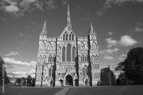 Black and white image of Salisbury Cathedral which has the tallest church spire in the UK photographed on a sunny day. With space for text.
