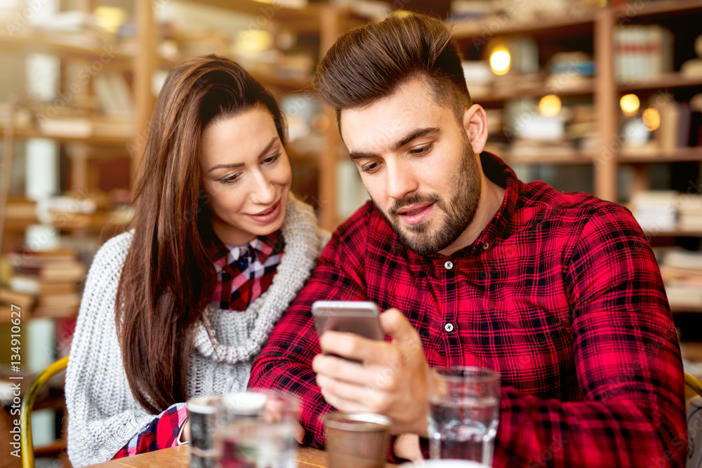 Couple at restaurant looking at smart phone. Couple at restaurant looking at smart phone.