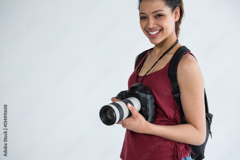 Fototapeta premium Happy female photographer standing in studio