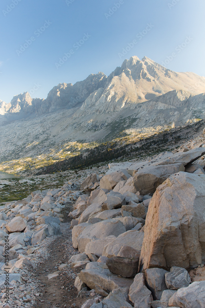 Sunrise lights the granite peaks around a deep alpine valley in the high sierra