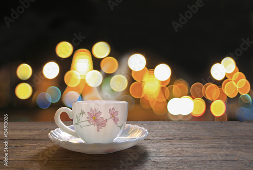 Hot coffee on wooden table with colorful bokeh background,concep