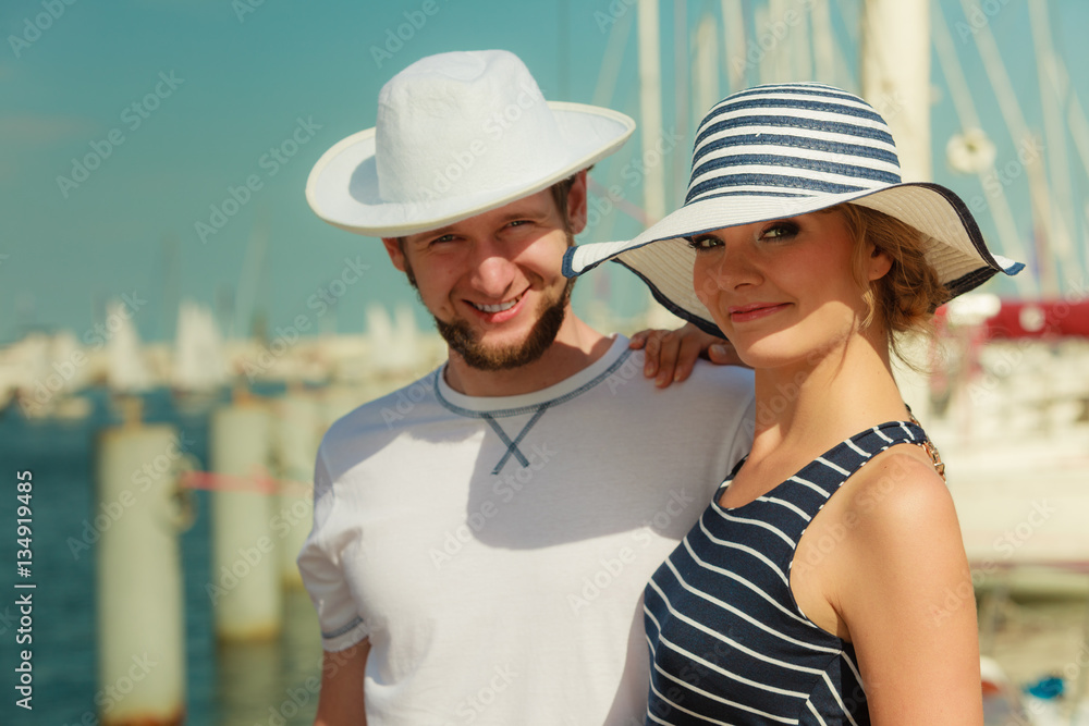 Tourist couple in marina against yachts in port
