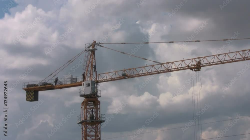 Workers on the building crane on construction site Workers on the building crane on construction site