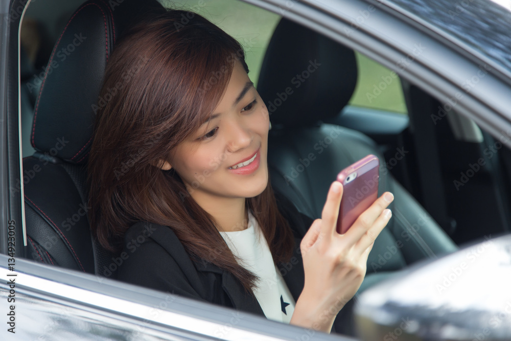 Asian woman driving happy about her new car or drivers license