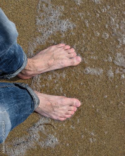 young guy with bare feet on the beach of the Sea of       Japan
