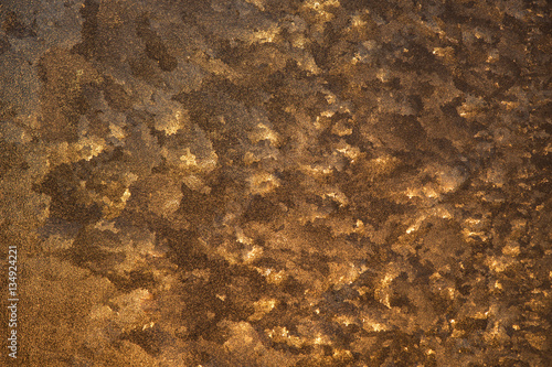 unusual patterns of frost on a window at sunset