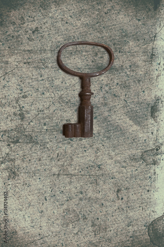 Old key on the old textured paper with natural patterns © dpaint