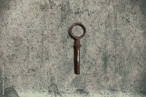 Old key on the old textured paper with natural patterns © dpaint