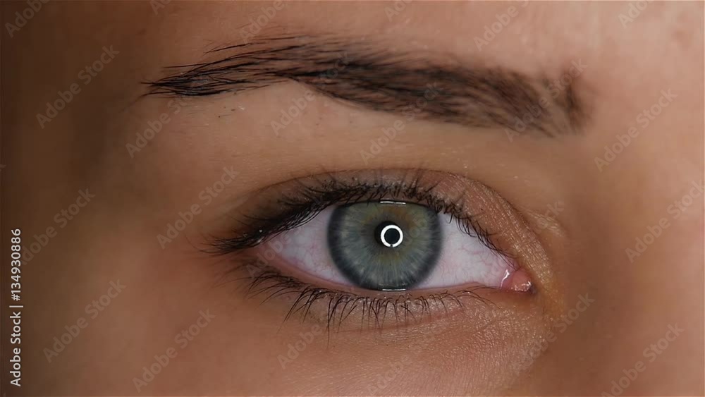 Girl opens her eyes and her pupil increases and narrows. Slow motion. Close up