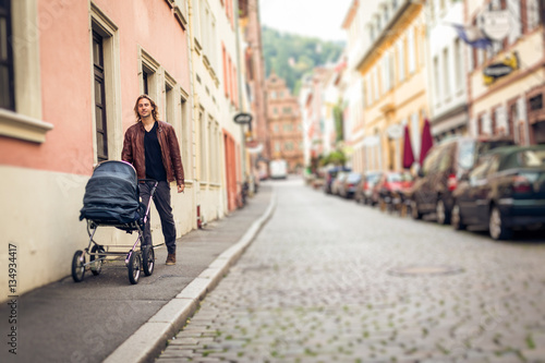 Young Father With Baby Stroller In The City