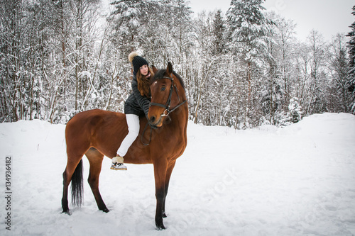 Young girl and horse in a winter forest