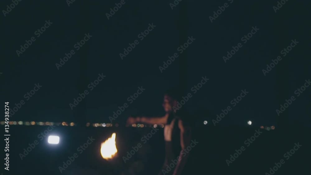 Attractive muscular guy breathes fire at night, slow motion Attractive muscular guy breathes fire at night, slow motion
