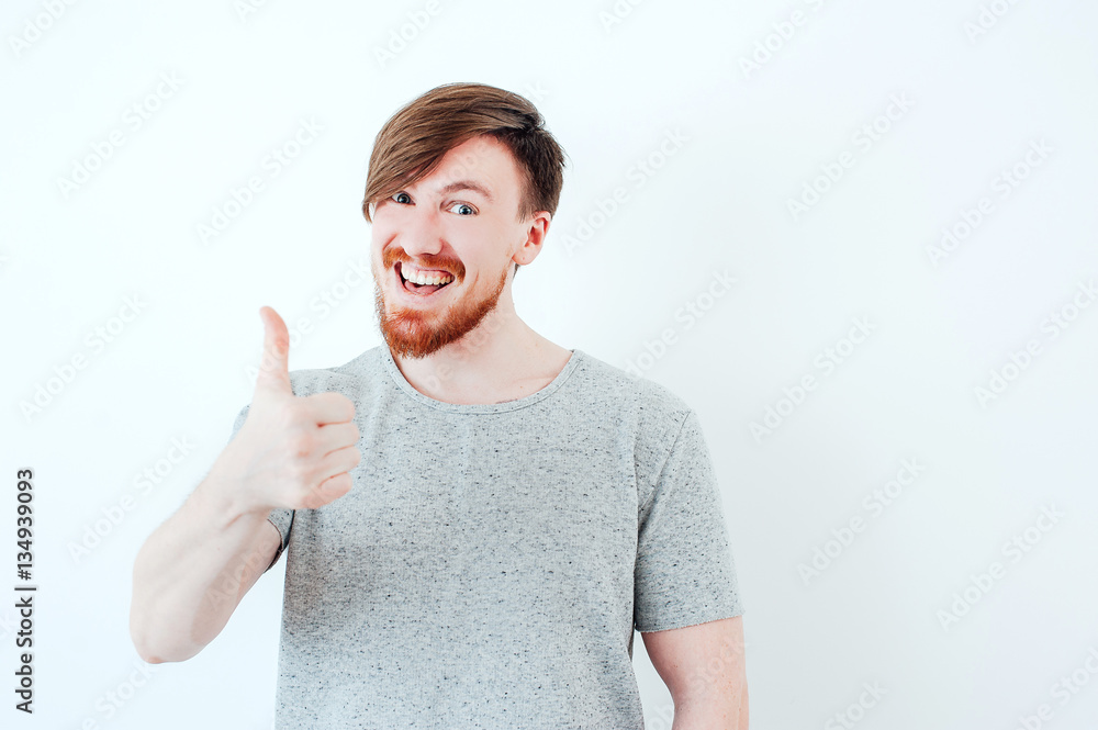 Bearded man showing thumbs up on a light background. Success Bearded man showing thumbs up on a light background. Success