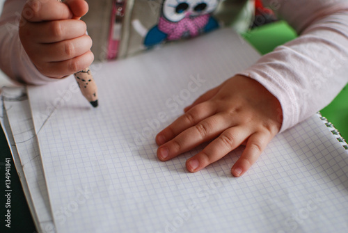 Child drawing with crayons on a piece of paper
