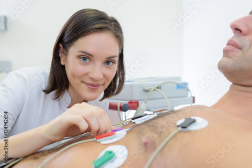 Portrait of nurse applying heart pads to patient