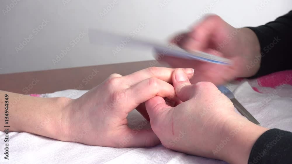Woman receiving a manicure by a beautician Woman receiving a manicure by a beautician