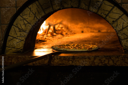 Pizza cucinata in forno tradizionale a legna 