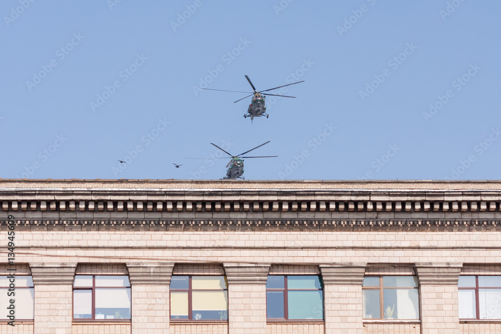 Two Mil Mi-8 (Hip) medium transport helicopters fly over building