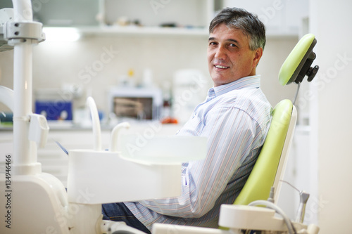 Senior male patient on dental chair waiting for the treatment.
