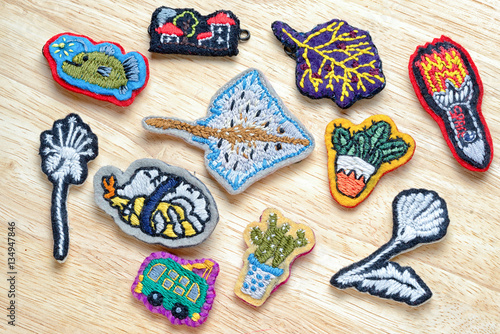 Group of homemade embroidery brooches on a wooden table