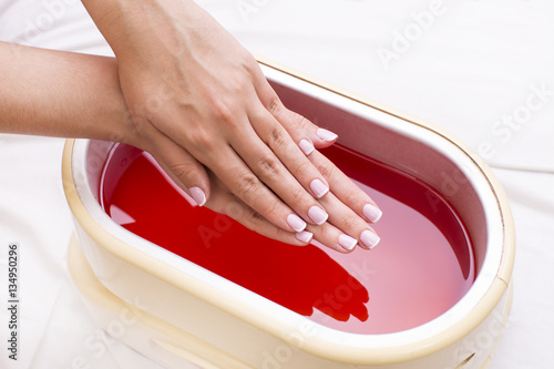 Tela Process paraffin treatment of female hands in beauty salon