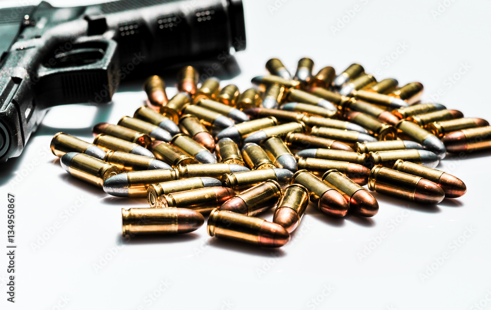 close up of 9 mm. bullets with hand gun on white background