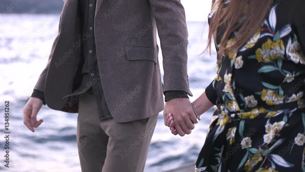 Couple walking holding hands near the sea. Couple walking holding hands near the sea.
