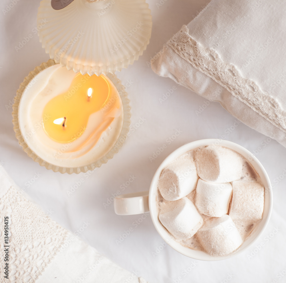 White cup of hot cocoa with marshmallows on white wooden backgro White cup of hot cocoa with marshmallows on white wooden backgro