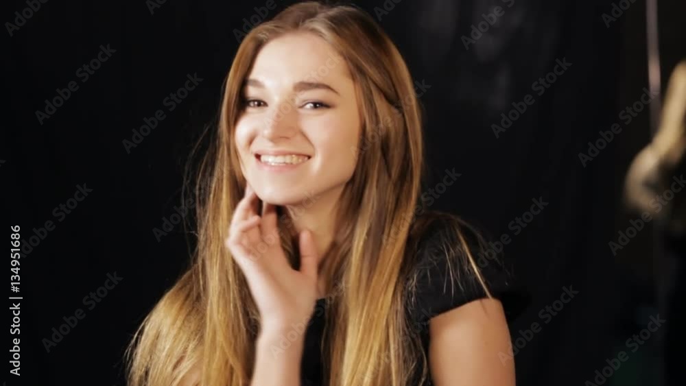 Beautiful woman posing with hands at face - black background Beautiful woman posing with hands at face - black background