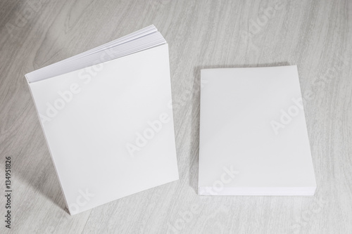 Real 3D paperback white books on a wood background