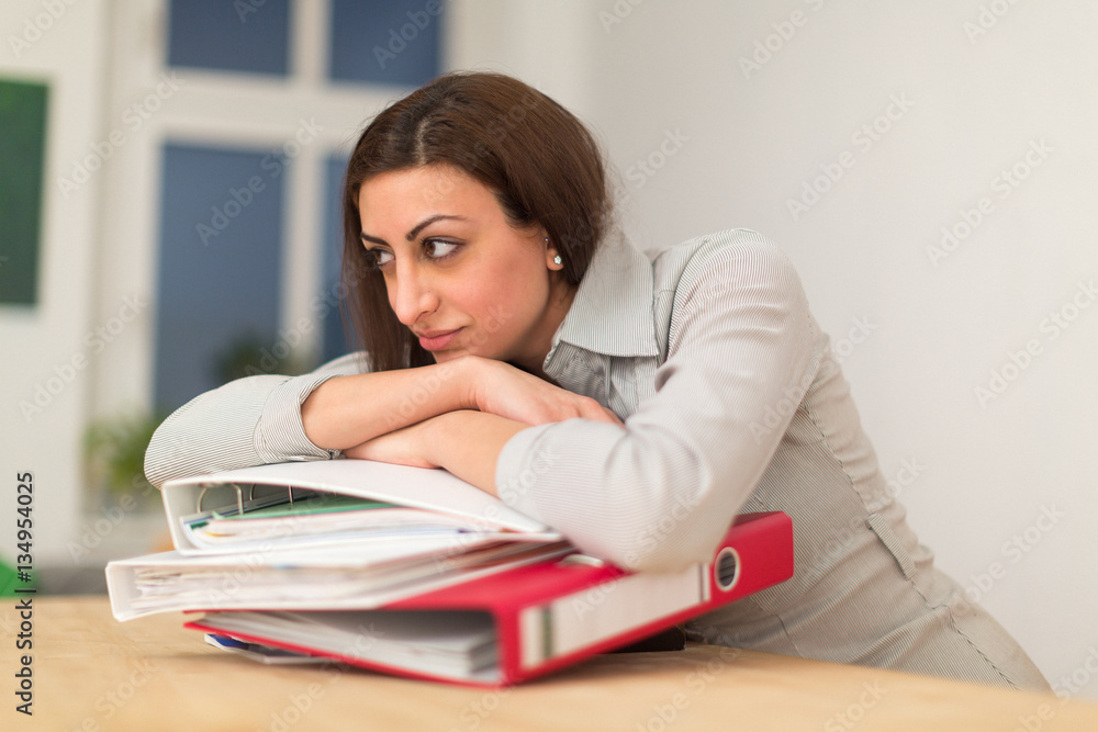 Exhausted woman lying on folders Exhausted woman lying on folders