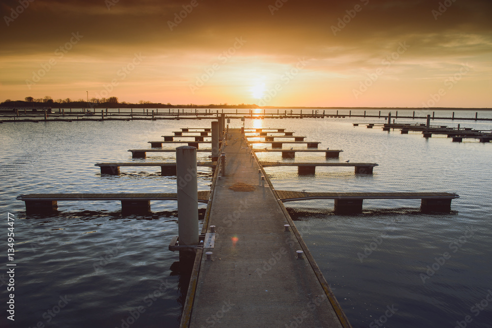 Obraz premium Yacht port over orange sunset