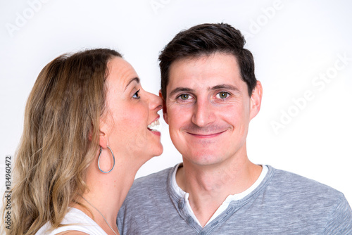 young woman whisper in the ear of her boyfriend