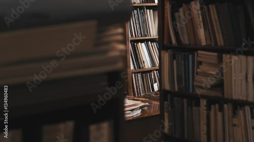 Bookcases full of books and document folders in the old style library. Dolly shot