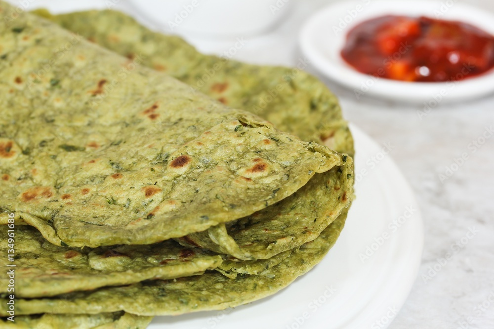 Methi Paratha (Thepla) / Indian flat bread using fenugreek leaves, selective focus Methi Paratha (Thepla) / Indian flat bread using fenugreek leaves, selective focus